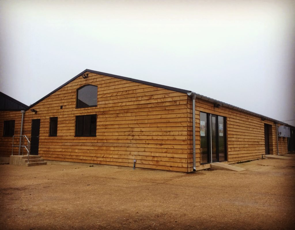 Wood clad farm shop building with glass front doors
